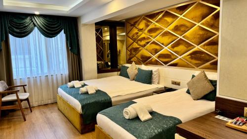 a hotel room with two beds and a table at Burj Al Istanbul in Istanbul