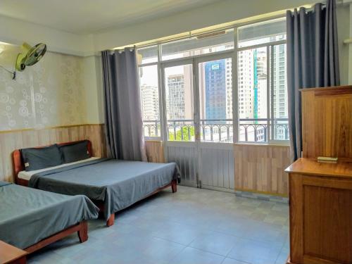 a bedroom with two beds and a large window at Tuệ Tĩnh Tower 21 in Nha Trang