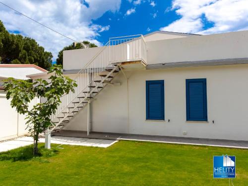 a white house with a staircase on it at CALALUNGA PIETRAGRANDE - Exclusive Shoreline Haven in Montepaone Lido