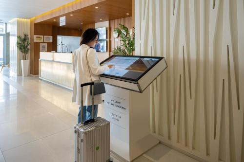 a woman standing next to a counter in a lobby at Novotel Jeddah Tahlia in Jeddah