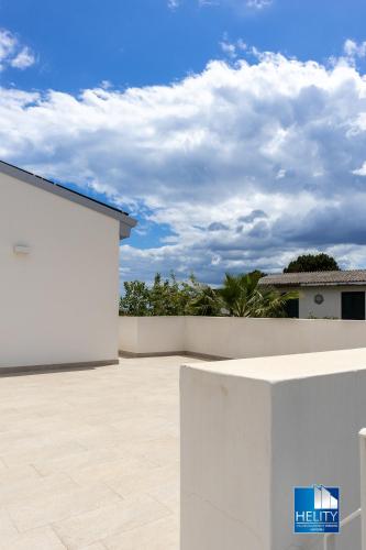 a white wall with a fence in front of a house at CALALUNGA PIETRAGRANDE - Exclusive Shoreline Haven in Montepaone Lido