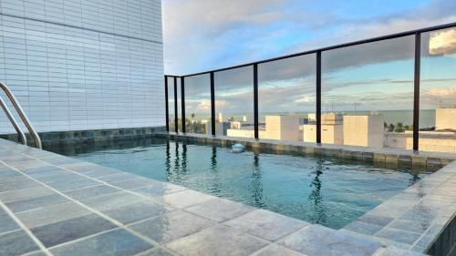 a swimming pool on a building with a view of the city at Studio Flat Tramonto in João Pessoa