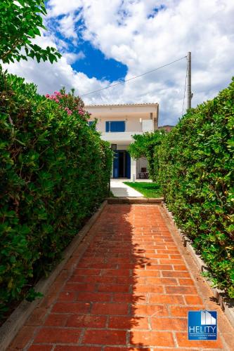 a brick pathway leading to a house with a building at CALALUNGA PIETRAGRANDE - Exclusive Shoreline Haven in Montepaone Lido