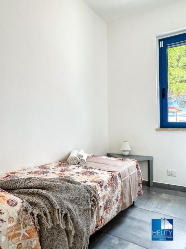 a bedroom with a bed and a window at CALALUNGA PIETRAGRANDE - Exclusive Shoreline Haven in Montepaone Lido
