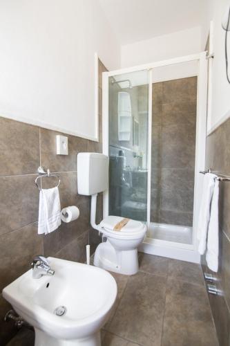 a bathroom with a toilet and a sink and a shower at Villa Liliana in Cervia