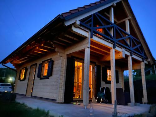 a house with a large open door in the evening at Loghouse Brunka - Escape from life on a highway in Gornja Radgona