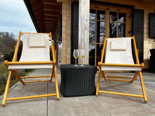 two chairs and a table with a glass of wine at Loghouse Brunka - Escape from life on a highway in Gornja Radgona