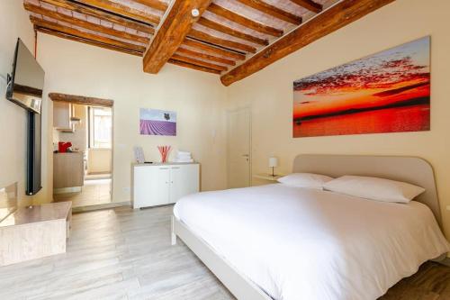 a bedroom with a white bed and a television at The View - Sunset & Relax - Suite - Appartamenti Vista Lago in Passignano sul Trasimeno