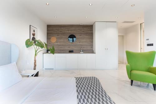 1 dormitorio con 1 cama y 1 silla verde en Centro Design Apartments - Półwiejska en Poznan