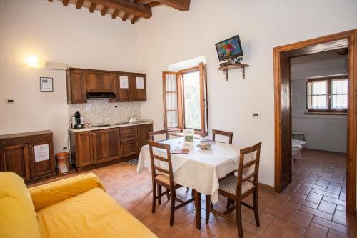a kitchen and dining room with a table and chairs at Garden Relais Le Fontanelle in Montescudaio