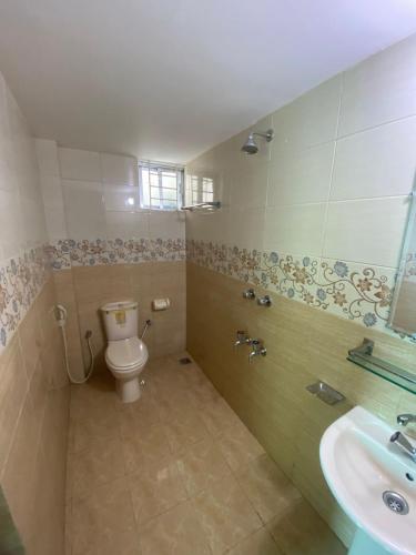a bathroom with a toilet and a sink at Home Away Home in Dhaka