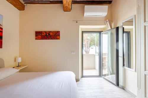 a bedroom with a bed and an open door at The View - Sunset & Relax - Suite - Appartamenti Vista Lago in Passignano sul Trasimeno