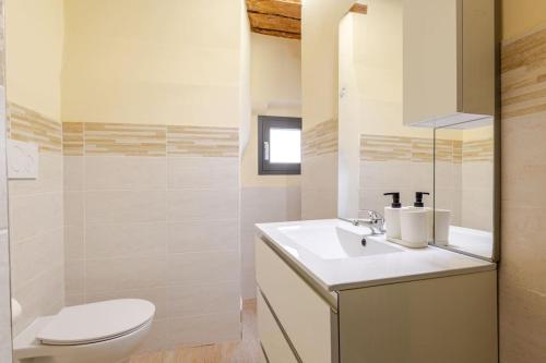 a white bathroom with a toilet and a sink at The View - Sunset & Relax - Suite - Appartamenti Vista Lago in Passignano sul Trasimeno