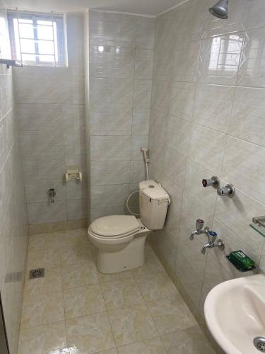 a bathroom with a toilet and a sink at Home Away Home in Dhaka