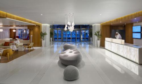 a lobby of a hotel with chairs and tables at Novotel Jeddah Tahlia in Jeddah