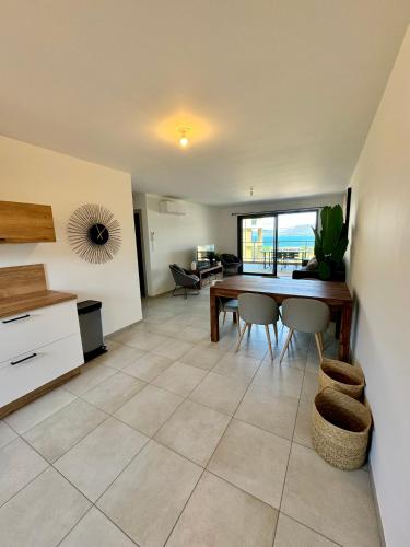 une cuisine et une salle à manger avec une table et des chaises dans l'établissement T3 de standing neuf vue mer, à Propriano