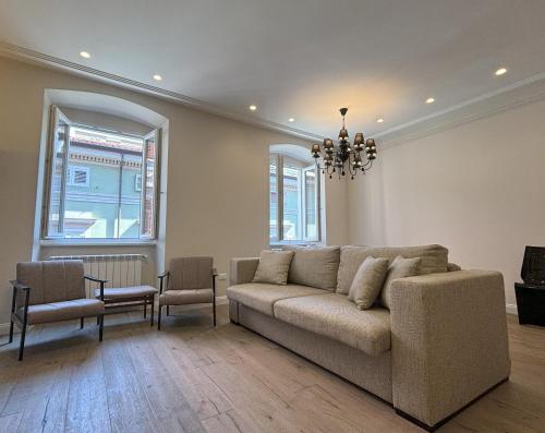 a living room with a couch and a table and chairs at Il Sogno Apartment in Trieste