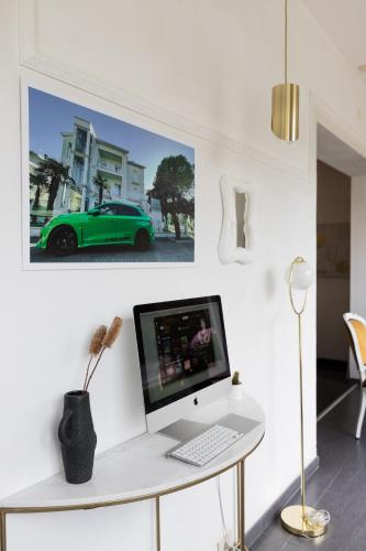 a desk with a computer and a green car on a wall at Villa Liliana in Cervia