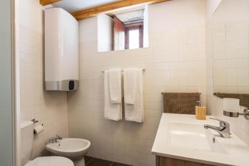 a white bathroom with a sink and a toilet at Cerdeira - Home for Creativity in Lousã