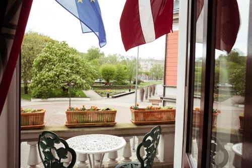 a balcony with a table and chairs and a fountain at Art Hotel Roma in Liepāja