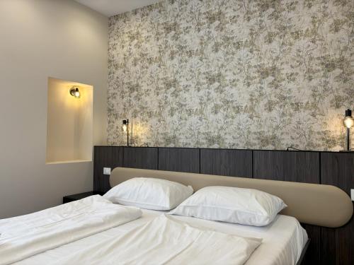 a bedroom with two white beds and a wallpaper at Il Sogno Apartment in Trieste