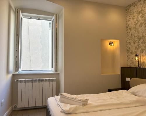 a bedroom with a bed and a window at Il Sogno Apartment in Trieste