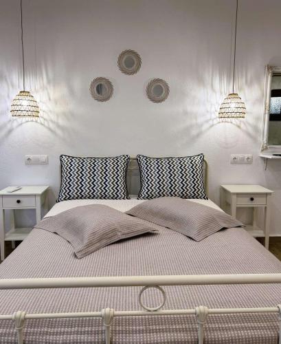 a bedroom with a bed with two tables and two lights at Afroditi's House studioB4 in Ormos Panagias