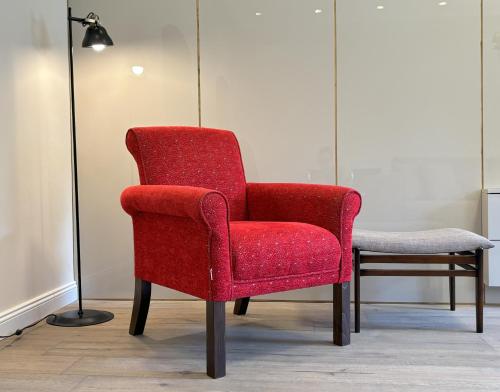 a red chair and a stool in a room at Il Sogno Apartment in Trieste