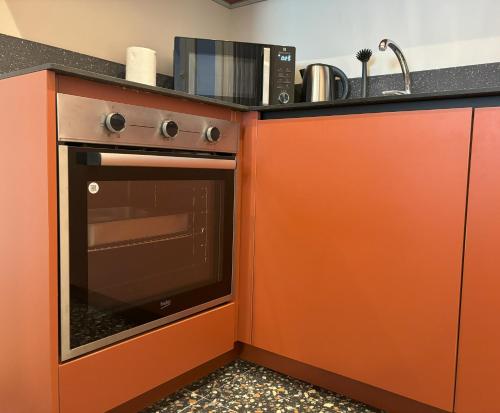 a kitchen with an orange stove and a sink at Il Sogno Apartment in Trieste