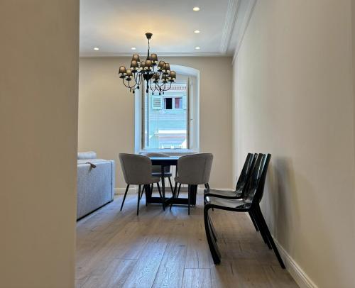 a dining room with a table and chairs and a chandelier at Il Sogno Apartment in Trieste
