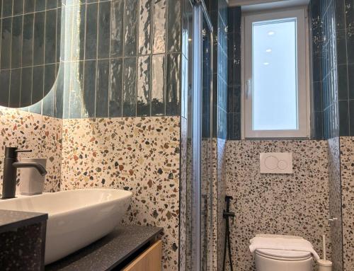a bathroom with a sink and a toilet and a window at Il Sogno Apartment in Trieste