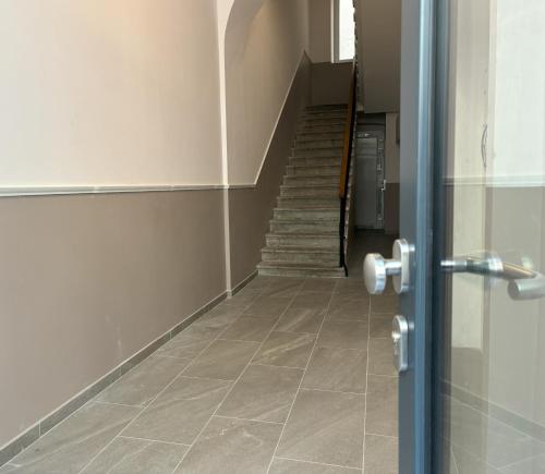 a hallway with a staircase and a door with a tile floor at Il Sogno Apartment in Trieste