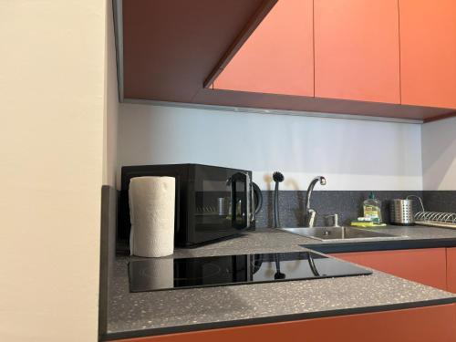 a kitchen with a microwave and a sink at Il Sogno Apartment in Trieste