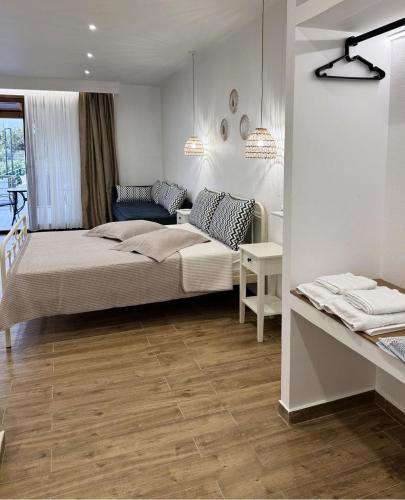 a bedroom with a bed and a couch and a table at Afroditi's House studioB4 in Ormos Panagias