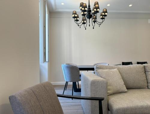 a dining room with a table and a couch and chairs at Il Sogno Apartment in Trieste