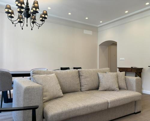 a living room with a couch and a chandelier at Il Sogno Apartment in Trieste
