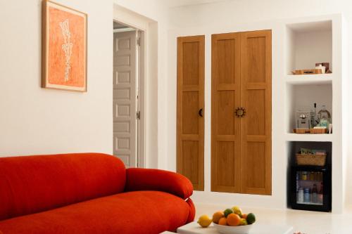 an orange couch in a room with a door at Petunia Ibiza, a Beaumier hotel in Cala Vadella