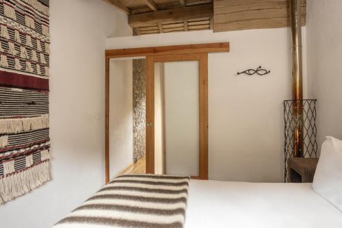 a bedroom with a bed and a window at Cerdeira - Home for Creativity in Lousã