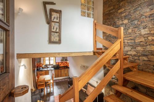 a staircase in a room with a stone wall at Cerdeira - Home for Creativity in Lousã
