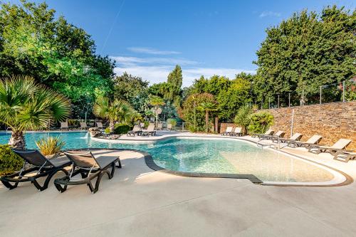 - une piscine entourée de chaises et de chaises dans l'établissement Camping Domaine Les Oréades - Maeva Sélection, à Sanguinet