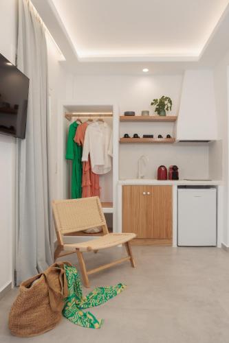 a living room with a chair and a kitchen at Agia Anna Living in Agia Anna Naxos