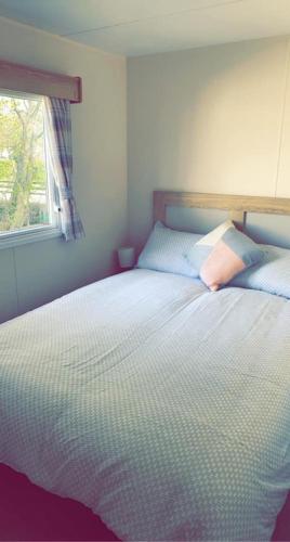 a bedroom with a bed with two pillows and a window at Lakeside East 16 - Haggerston Castle in Berwick-Upon-Tweed