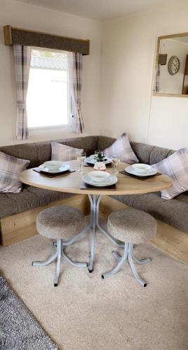 a wooden table with two chairs in a living room at Lakeside East 16 - Haggerston Castle in Berwick-Upon-Tweed