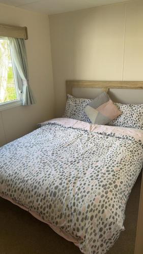 a bedroom with a bed with a leopard print comforter at Lakeside East 16 - Haggerston Castle in Berwick-Upon-Tweed