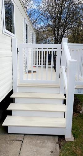 a white staircase leading to a white house at Lakeside East 16 - Haggerston Castle in Berwick-Upon-Tweed