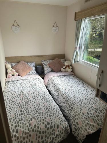 two twin beds in a room with a window at Lakeside East 16 - Haggerston Castle in Berwick-Upon-Tweed