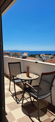 a patio table and chairs on a balcony with a view at Apartments Villa Bella Vista Hvar in Hvar