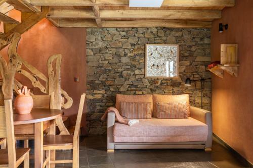 a living room with a couch and a stone wall at Cerdeira - Home for Creativity in Lousã
