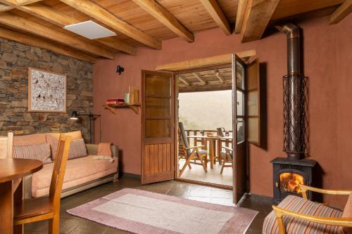 a living room with a couch and a wood stove at Cerdeira - Home for Creativity in Lousã