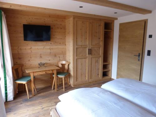 a bedroom with a bed and a desk and a tv at Gästehaus Becher, Kreuth-Point in Kreuth